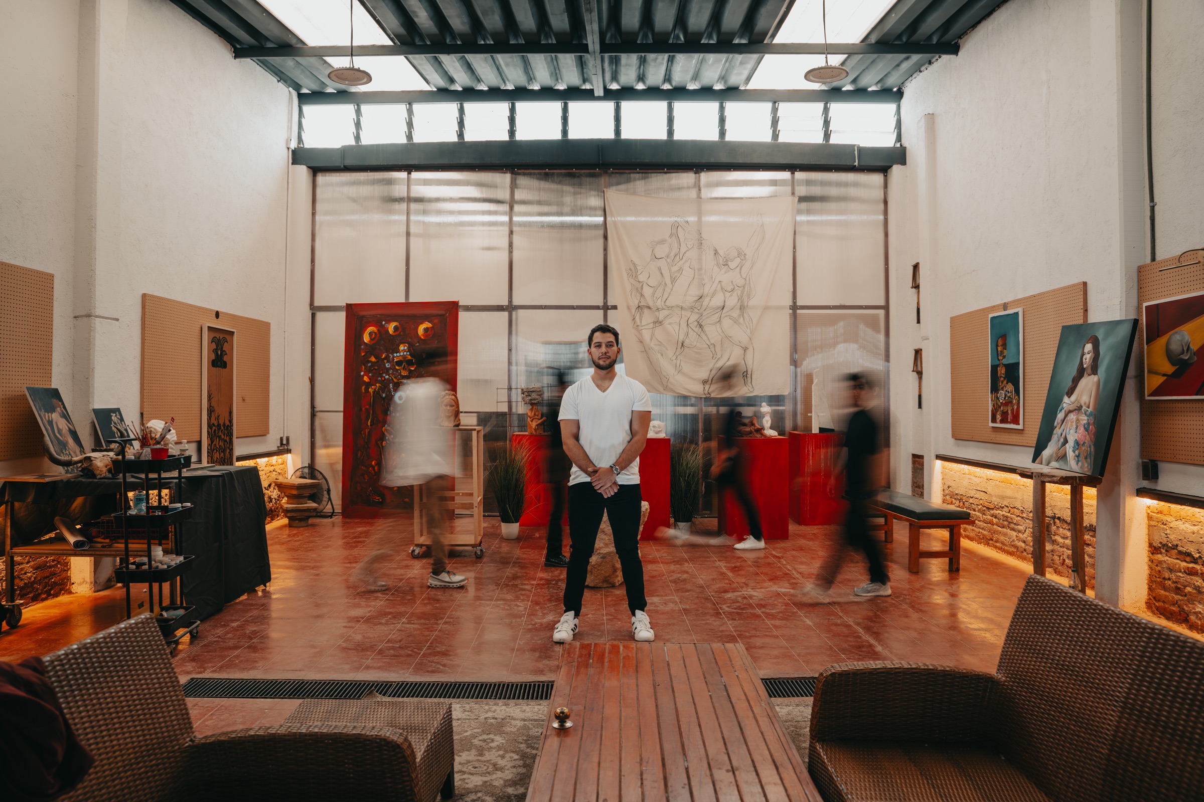 Leonel de pie en su taller rodeado de su obra