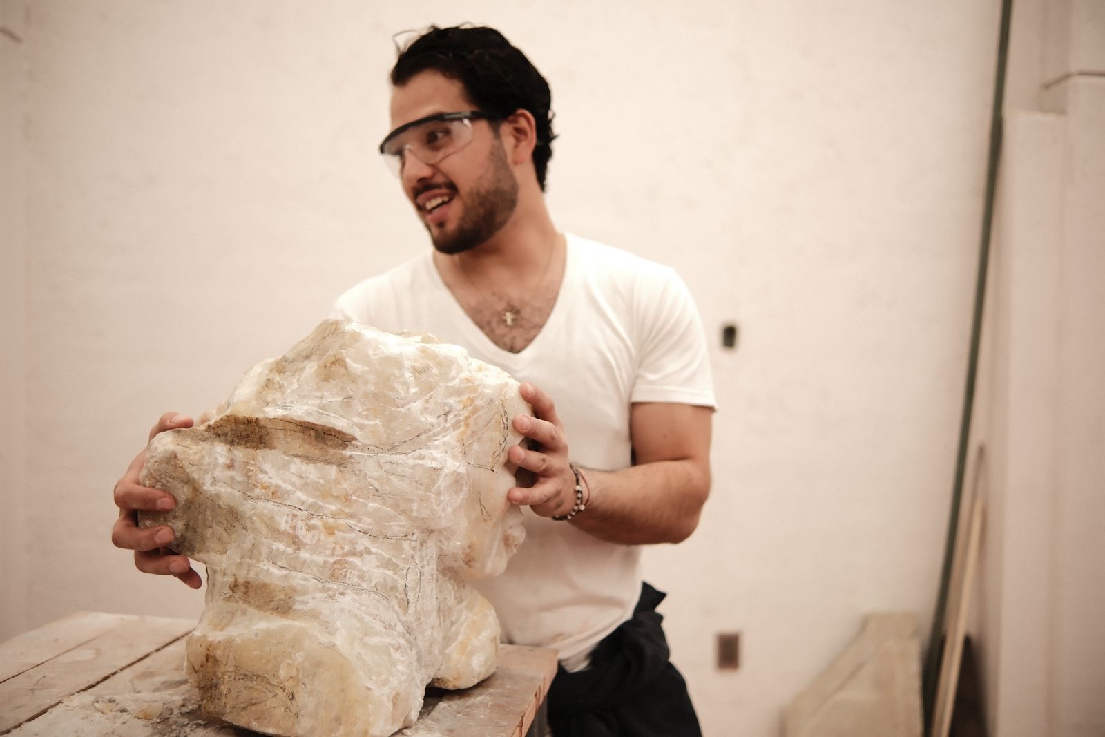 Leonel sostiene un bloque de piedra recién tallado