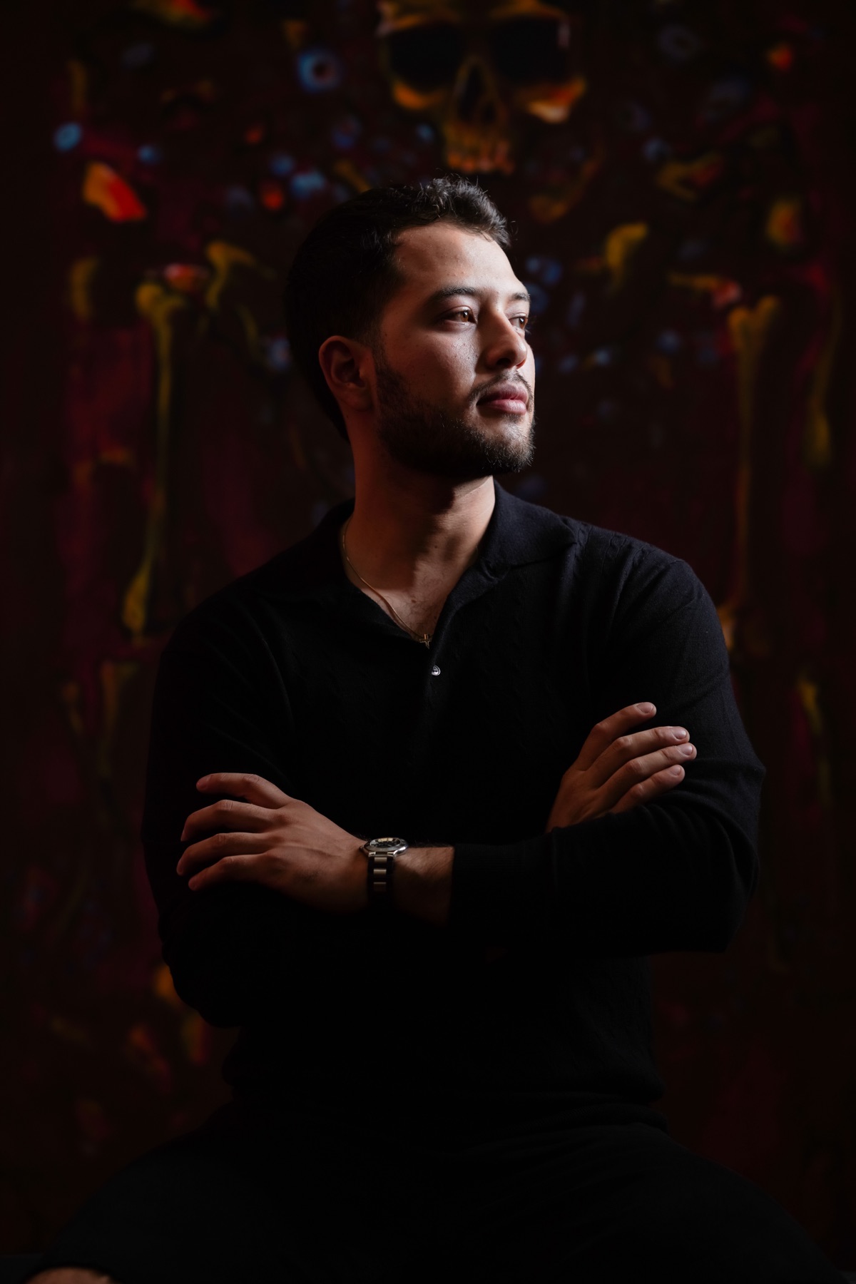 Retrato de Leonel Leyva Ortiz frente a su pintura La reina roja